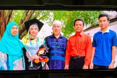 Kamarudin Salleh, bapa kepada salah seorang penumpang helikopter yang terhempas berhampiran Long Lellang, Sarawak, Dr. Ainul Baroah, menunjukkan gambar anaknya (dua, kiri) bersama ahli keluarga ketika ditemui pemberita di kediamannya di Kampung Baung, Pengkalan Chepa di sini malam ini.