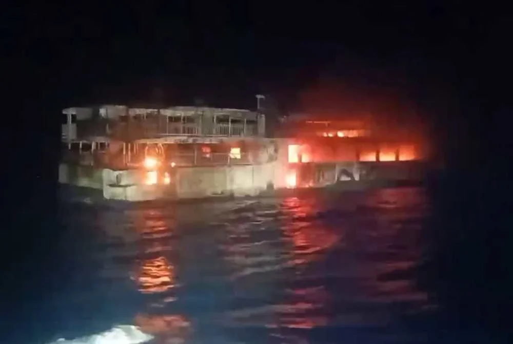 Tangkap layar tular daripada video edaran Pengawal Pantai Filipina menunjukkan kapal yang terbakar. - AFP