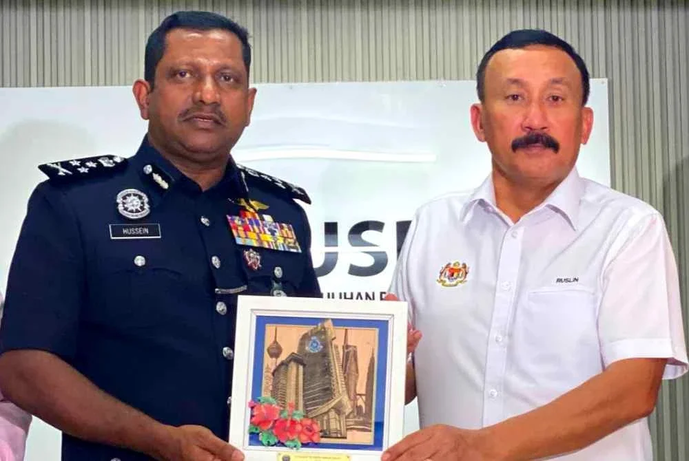 Hussein (kiri) menyampaikan cenderamata kepada Ruslin sempena Lawatan Strategik ke PUSPEN Bachok di Bachok pada Khamis.