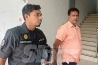 Sultan Mohamed (kanan) diiring pegawai Swcorp ketika mahu menjelaskan denda kerana membuang sampah merata.