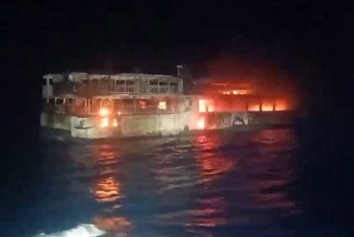 Tangkap layar tular daripada video edaran Pengawal Pantai Filipina menunjukkan kapal yang terbakar. - AFP