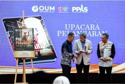 Sultan Sharafuddin Idris Shah (tengah) berkenan menerima buku daripada penulis Dr Malik Yatam (kiri) pada Majlis Pelancaran Buku ‘Ph.D Dari Penjara’ di Pustaka Raja Tun Uda. Foto Bernama