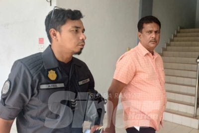 Sultan Mohamed (kanan) diiring pegawai Swcorp ketika mahu menjelaskan denda kerana membuang sampah merata.
