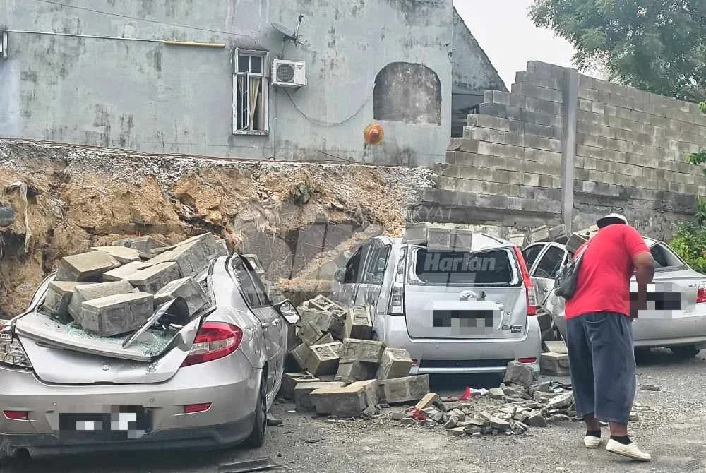 Keadaan tiga kereta yang dihempap tembok konkrit pagar di Seremban pada Sabtu.
