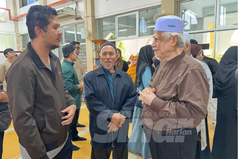 Muhammad Faiz (kiri) dan Kamarudin (tengah) yang mengiringi jenazah ke Kelantan.