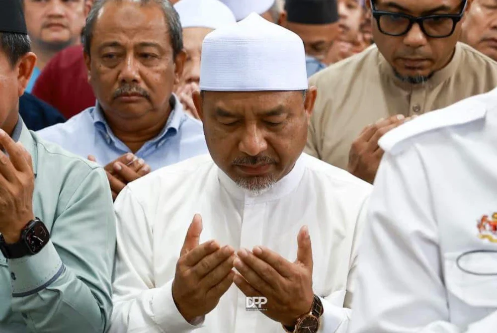 Mohd Nassuruddin (kiri) menunaikan solat jenazah dan mendoakan Allahyarham Dr Ainul. - FOTO : Facebook Mohd Nassuruddin Daud