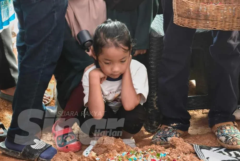 Anak sulung Allahyarham, Adelia Sofia sayu melihat pusara bapanya.