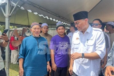 Kamarudin (kiri) yang menerima kehadiran Dr Dzulkefly (kanan) di Kelantan pada Ahad. 
