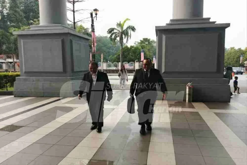 Jamil Khir (kiri) tiba di mahkamah pada Isnin.