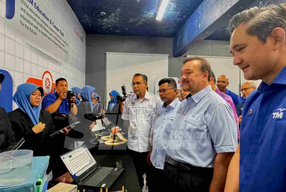 Amir (dua dari kanan) meninjau reruai yang dipamerkan oleh pelajar SMKA Al-Mashoor pada Program Tinjau Pelaksanaan Sekolah Angkat Madani TM.