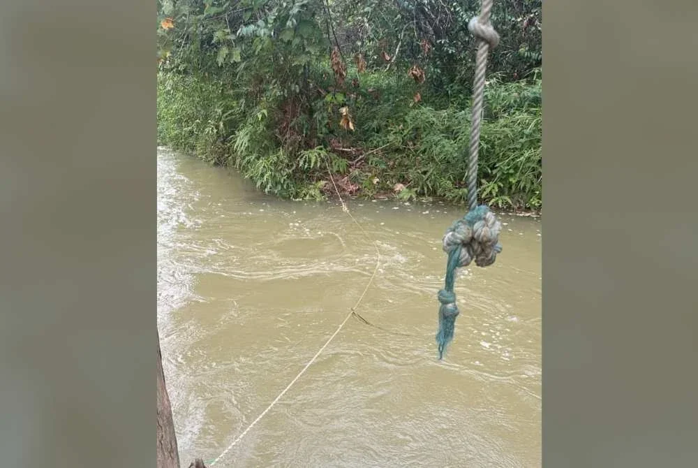 Tali diikat merentasi sungai dari sebatang pokok ke tebing bertentangan yang dipercayai digunakan oleh mangsa untuk bergayut sebelum terlepas pegangan dan dihanyutkan arus deras. Foto: Polis Rompin.