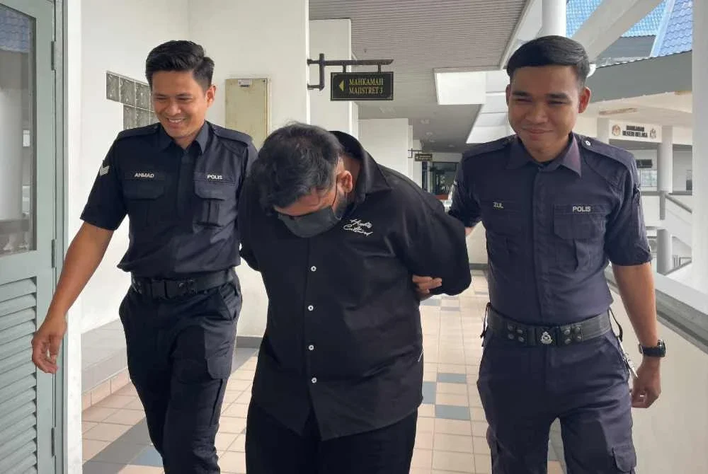Tertuduh (tengah) mengaku bersalah terhadap pertuduhan dibacakan ke atasnya.
