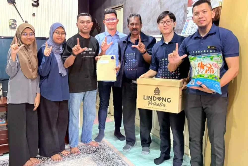 Anthony (tiga dari kanan) bersama Kar Hing (empat dari kanan) menyantuni keluarga Allahyarham Faridah Hanum di kediaman mereka di Taman Pinji Mewah, Ipoh menerusi program Ziarah Prihatin bersama PERKESO.