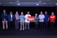 Ahmad Fadzli (lima dari kiri) menyerahkan tajaan kepada Emran di Kompleks Karangkraf pada Isnin. Foto: MOHD HALIM ABDUL WAHID
