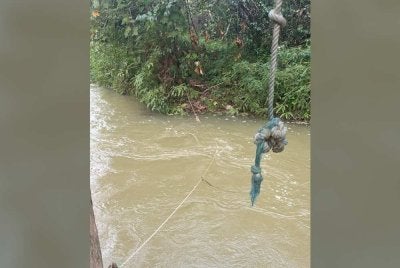 Tali diikat merentasi sungai dari sebatang pokok ke tebing bertentangan yang dipercayai digunakan oleh mangsa untuk bergayut sebelum terlepas pegangan dan dihanyutkan arus deras. Foto: Polis Rompin.
