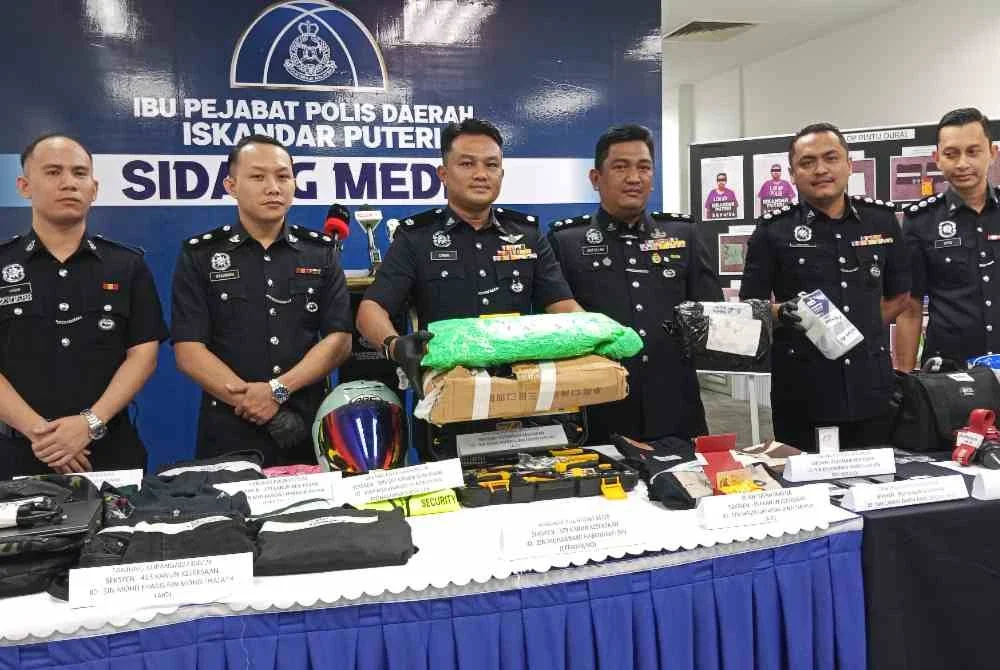 Saifullah (tiga dari kiri) menunjukkan parcel yang dicuri suspek pada sidang akhbar di IPD Iskandar Puteri pada Selasa.