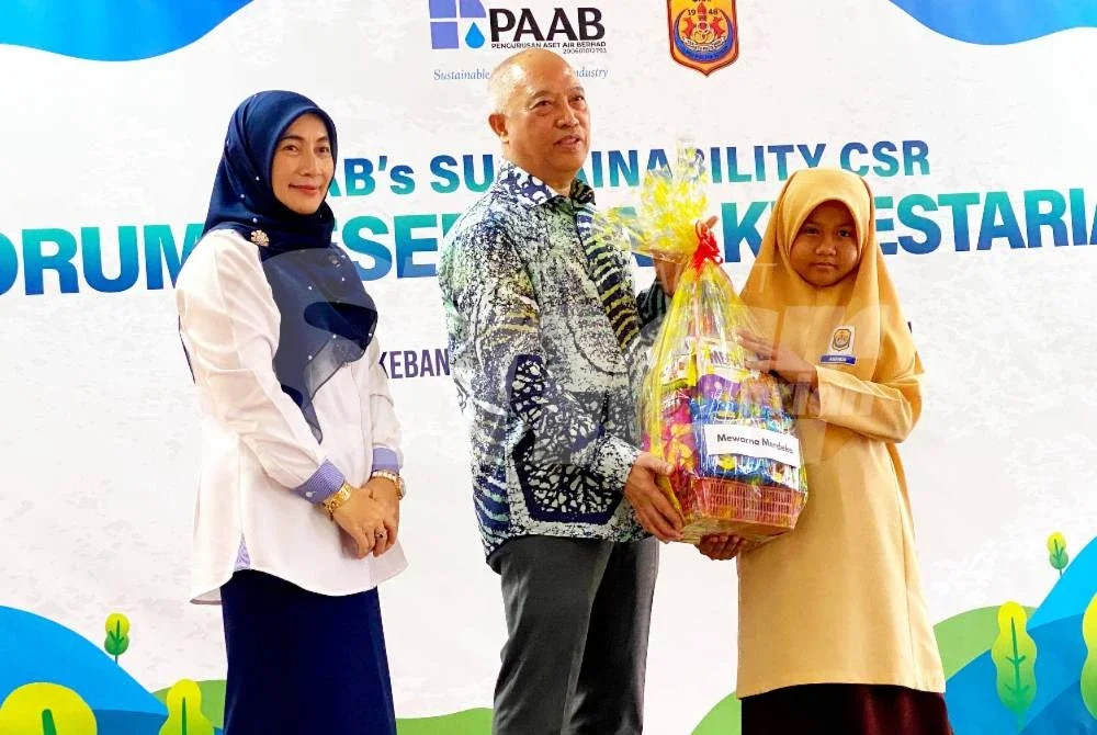 Ir Zulkiflee (tengah) bersama Nik Hasnas @ Nik Hafizah menyampaikan hadiah kepada pelajar terpilih semasa hadir pada Majlis Perasmian CSR Kelestarian PAAB di SKPH, Kota Bharu pada Selasa. Foto /HAZELEN LIANA KAMARUDIN