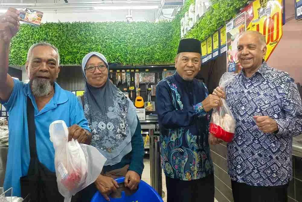 Ameer (kanan) dan Abdul Fatah (tiga dari kiri) bersama pelanggan menunjukkan ayam RM1 yang ditawarkan pada hari pertama pembukaan Mydin Mart Port Dickson.