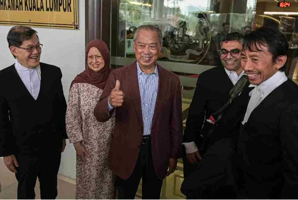 Muhyiddin ditemani isteri dan barisan peguamnya di Mahkamah Tinggi Kuala Lumpur, pada Selasa.