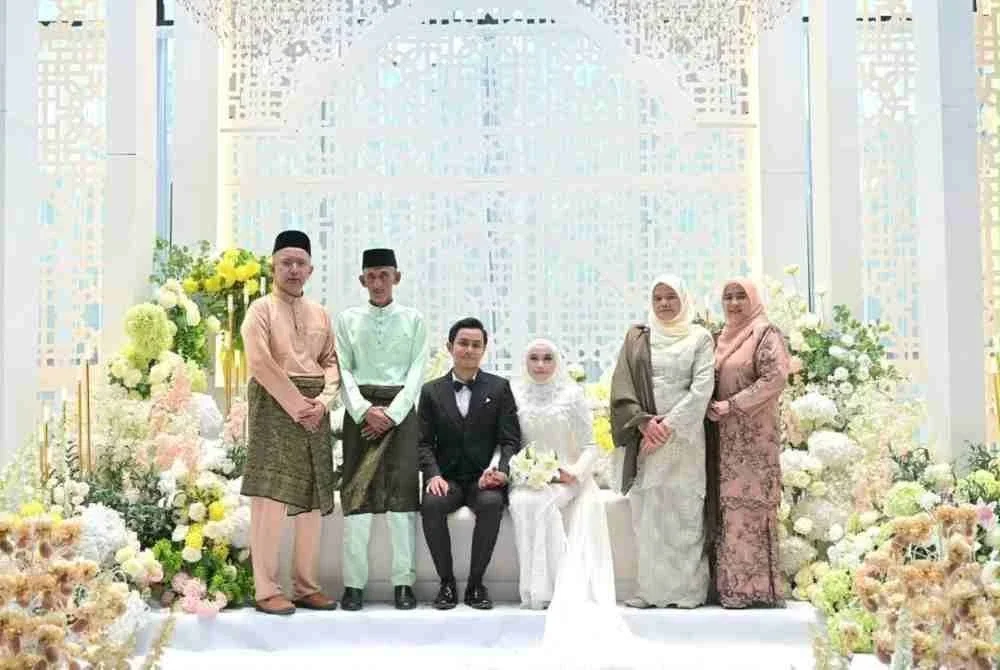 Pasangan pengantin bersama ibu bapa mereka.