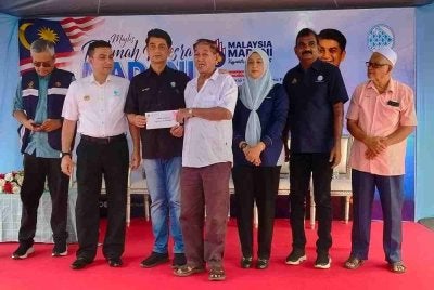 Muhammad Faiz (tiga dari kiri) menyampaikan sumbangan kepada penerima bantuan sempena Majlis Ramah Mesra Madani Pengerusi LKIM Bersama Nelayan Perak di Pejabat Penghulu Mukim Matang, di sini pada Selasa.