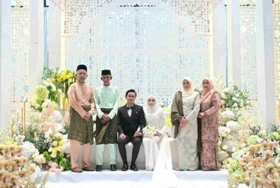 Pasangan pengantin bersama ibu bapa mereka.