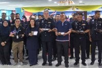 Mohd Jazri (tiga dari kanan) dan Mi-Chelle(tiga dari kiri) bergambar kenangan bersama Swee Sake (tengah) dan sebahagian anggota polis IPDTL.