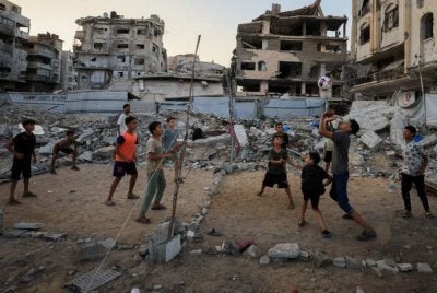 Kanak-kanak di Gaza Palestin bermain di tengah runtuhan bangunan yang musnah dibedil tentera Israel. Foto Reuters