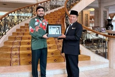 Tengku Amir Shah (kiri) menerima cenderahati daripada Abd Halim Aman di Istana Selangor, Bukit Kiara, Kuala Lumpur pada Isnin.