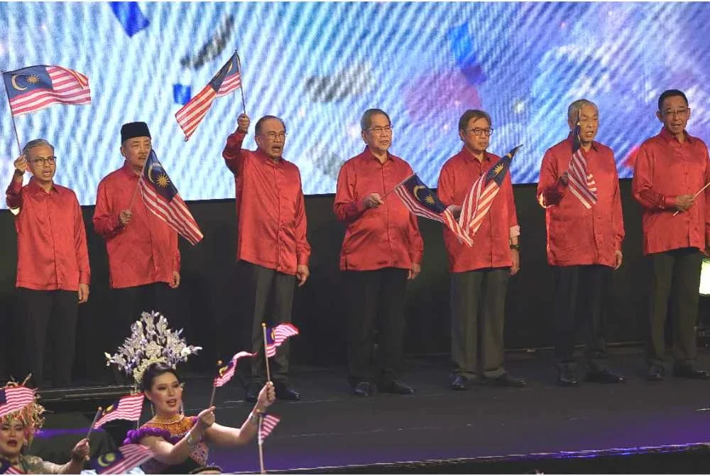 Anwar (tiga, kiri) bersama Wan Junaidi (tengah), Abang Johari (tiga, kanan), Hajiji (dua, kiri) dan barisan pemimpin lain mengibarkan Jalur Gemilang pada Sambutan Hari Malaysia Peringkat Kebangsaan 2026 di Pusat Konvensyen Borneo Kuching malam Rabu. Foto Bernama