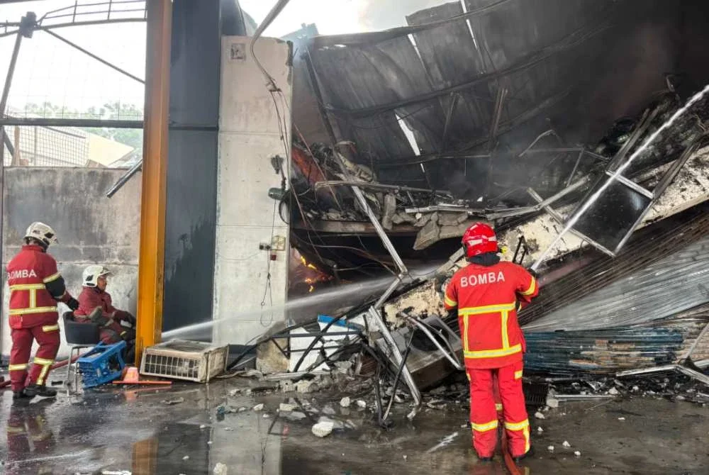 Anggota bomba sedang memadamkan kebakaran kilang di sini pada Khamis.