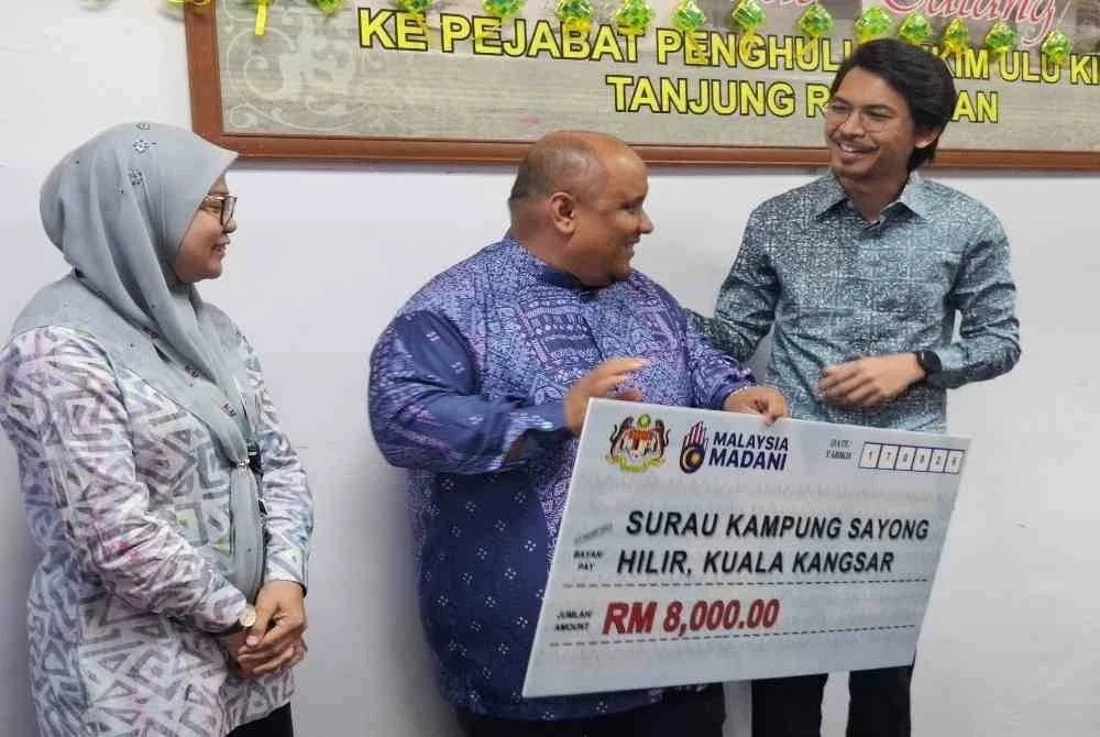 Surau Kampung Sayong Hilir antara 10 NGO yang menerima Sumbangan Peruntukan Perdana Menteri disampaikan Muhammad Kamil (kanan) di Pejabat Penghulu Mukim Hulu Kinta di Tanjung Rambutan pada Khamis.