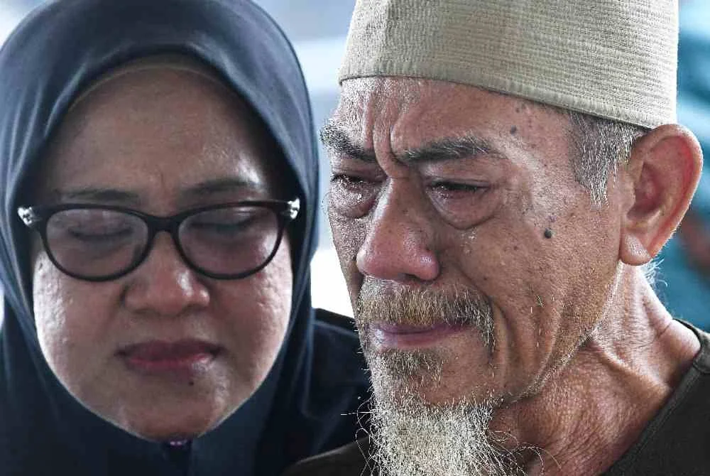 Bapa mangsa Ruhaizat Muhidin, 69, (kanan), tidak dapat menahan air matanya ketika menunggu perkembangan operasi mencari dan menyelamat (SAR) anaknya, Ridzuan, salah seorang daripada dua mangsa yang dilaporkan masih hilang di Pos Kawalan Tempat Kejadian, Jeti Sementa Klang pada Khamis. Foto Bernama