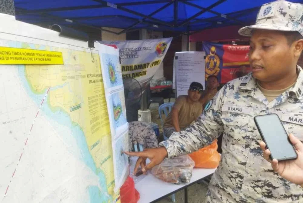 Mohd Syafiq menunjukkan lokasi operasi mencari pemancing hilang.
