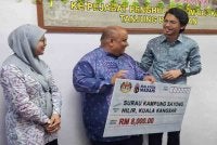 Surau Kampung Sayong Hilir antara 10 NGO yang menerima Sumbangan Peruntukan Perdana Menteri disampaikan Muhammad Kamil (kanan) di Pejabat Penghulu Mukim Hulu Kinta di Tanjung Rambutan pada Khamis.