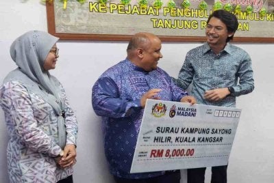 Surau Kampung Sayong Hilir antara 10 NGO yang menerima Sumbangan Peruntukan Perdana Menteri disampaikan Muhammad Kamil (kanan) di Pejabat Penghulu Mukim Hulu Kinta di Tanjung Rambutan pada Khamis.