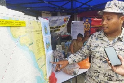 Mohd Syafiq menunjukkan lokasi operasi mencari pemancing hilang.