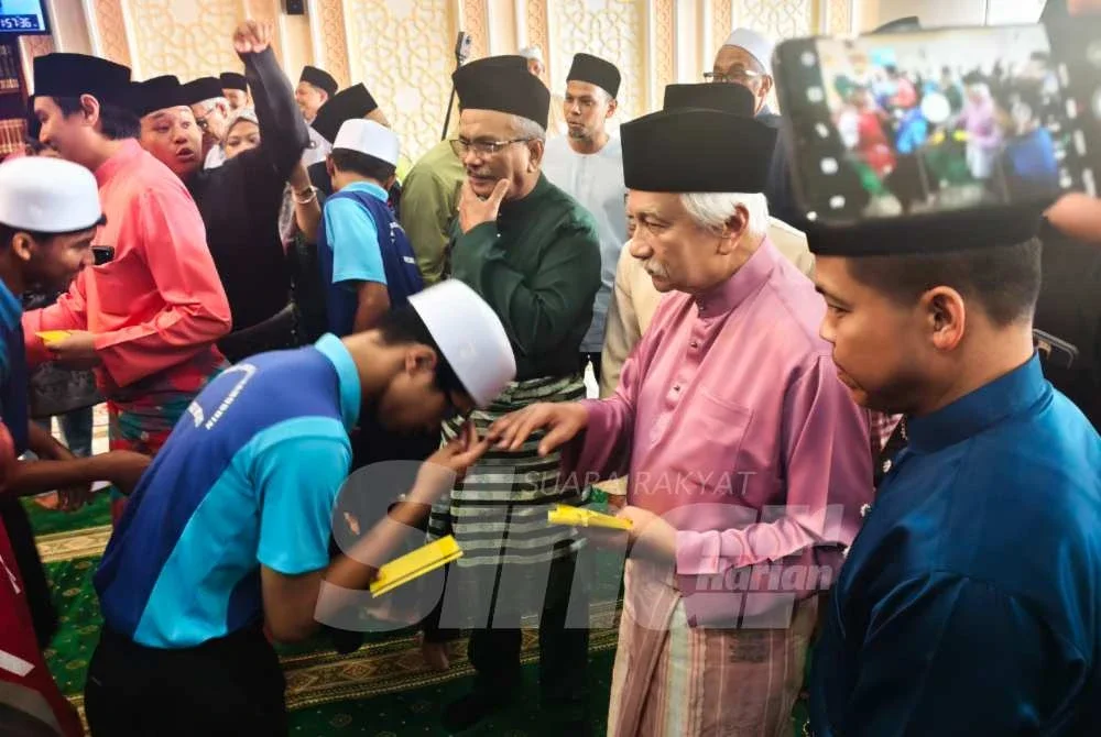 Tuanku Muhriz menyampaikan sumbangan kepada kanak-kanak yang hadir solat Jumaat di Masjid Diraja Tuanku Munawir. Foto SINAR HARIAN/SYAMILAH ZULKIFLI