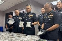 Ab Rahaman menunjukkan dadah yang dirampas dalam serbuan di Kluang, 13 September lalu