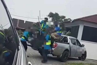 Tangkap layar video tular yang memaparkan penangkap anjing liar didakwa menunjukkan isyarat lucah.