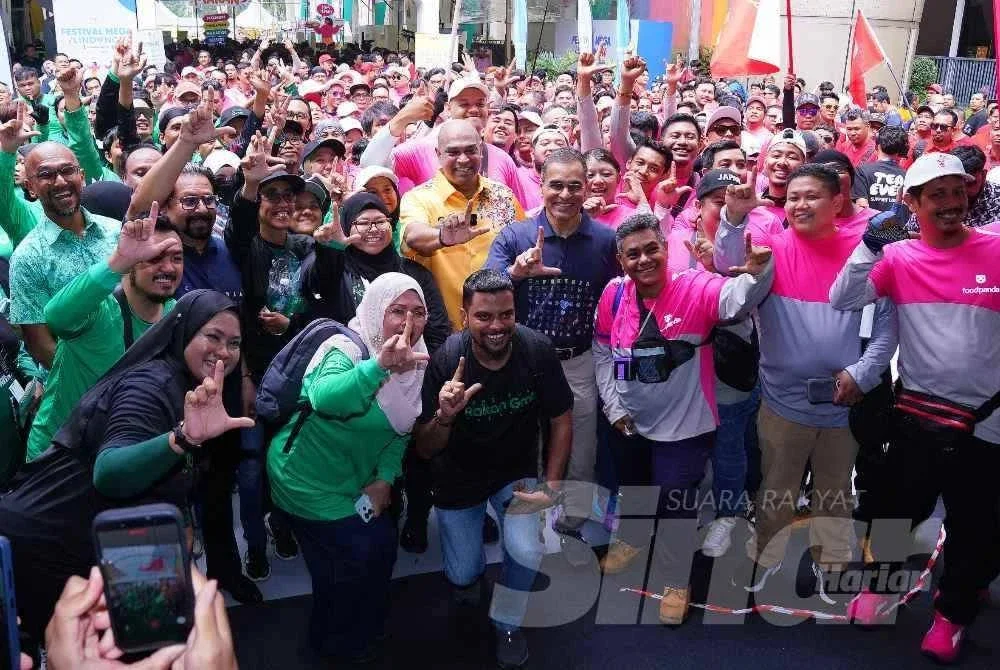 Datuk Seri Ramanan Ramakrishnan bergambar dengan pekerja e-hailing dan p-hailing pada Majis Perasmian Festival Mega i Lindung u di Strand Mall, Kota Damansara pada Sabtu. FOTO : MOHD HALIM ABDUL WAHID