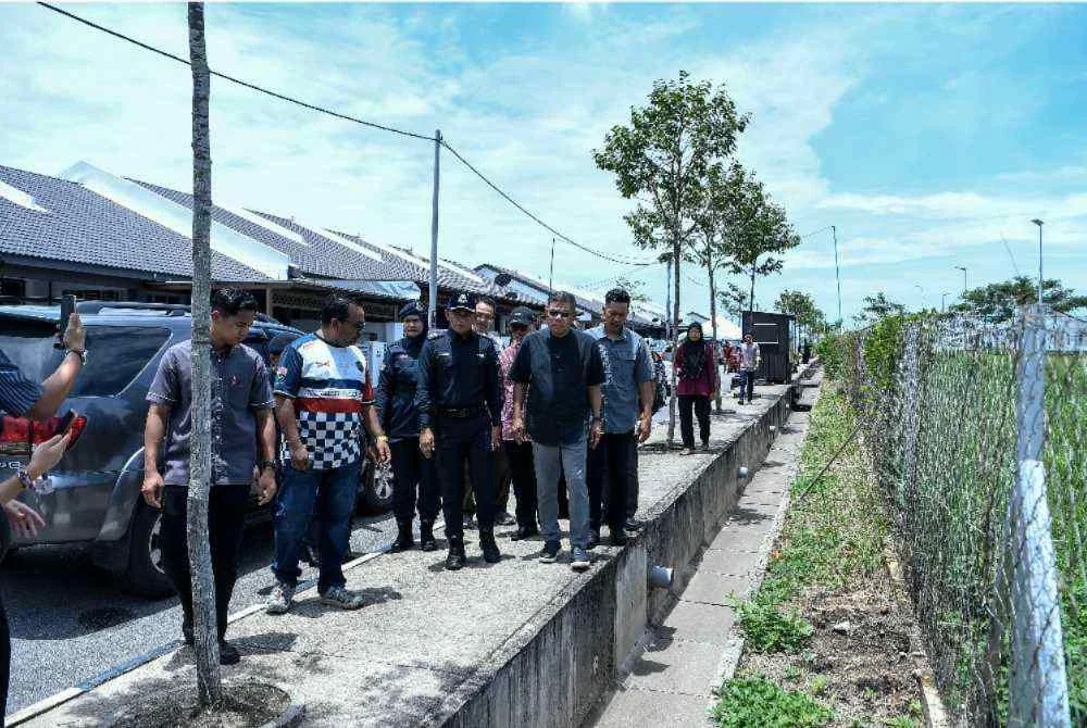 Saifuddin meninjau lokasi longkang yang meragut empat nyawa kanak-kanak dipercayai terjatuh ke dalam longkang ketika cuba mengambil bola yang jatuh di situ, di Taman Desa Kayangan pada Sabtu. Foto Bernama
