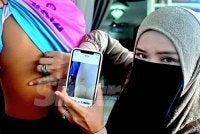 Rohani menunjukkan kesan kecederaan di bahagian belakang badan anaknya yang didakwa dipukul pelajar. 