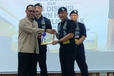Mohammad Azlin (kanan) menyampaikan sijil penghargaan kepada penerima sempena Majlis Peluncuran Taman Angkat Amanita 2026 dan Diskusi Town Hall Ketua Polis Perak Bilangan 2 di Dewan Bandaran Kinta di sini pada Sabtu.
