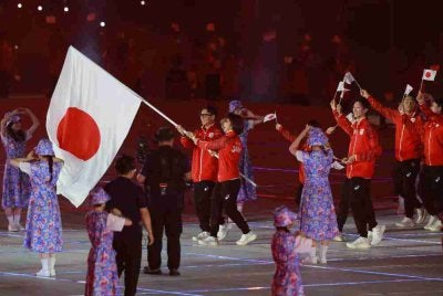 Anggota delegasi Jepun melambaikan bendera kebangsaan negara mereka semasa perarakan pada majlis pembukaan Sukan Asia 2026 di Stadium Paloma Mizuho di Nagoya. Foto AFP