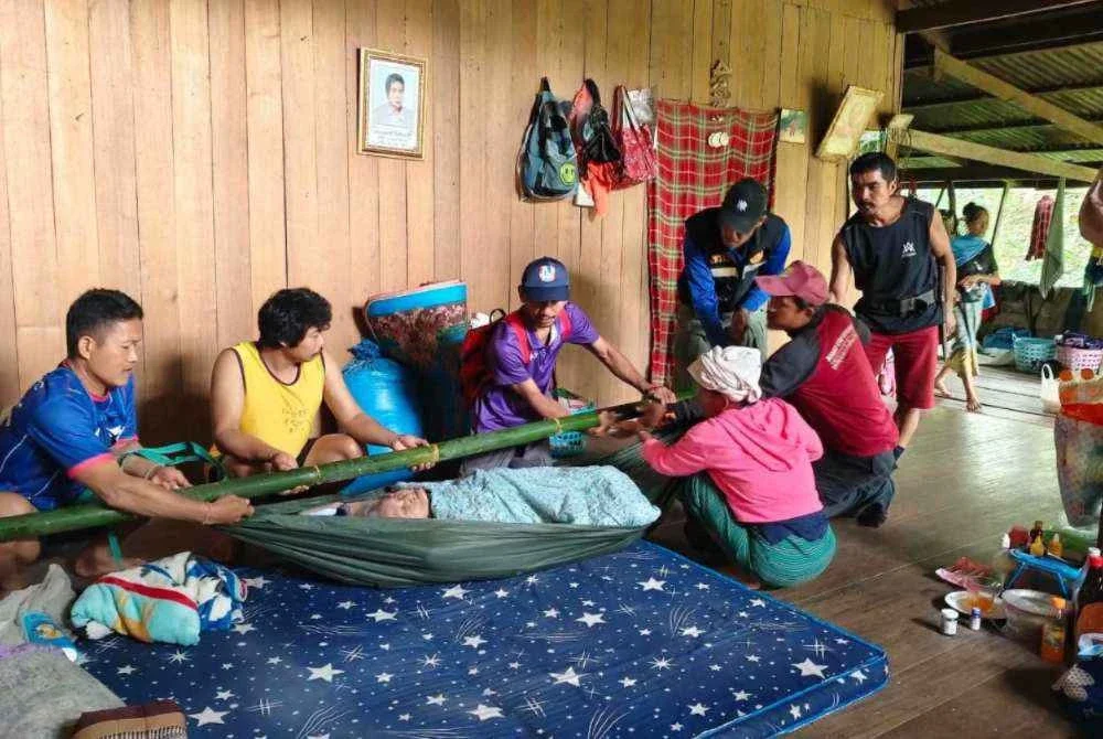 Penduduk mengusung wanita terlantar berusia 90 tahun bagi membolehkannya ke bank. - Foto: Facebook