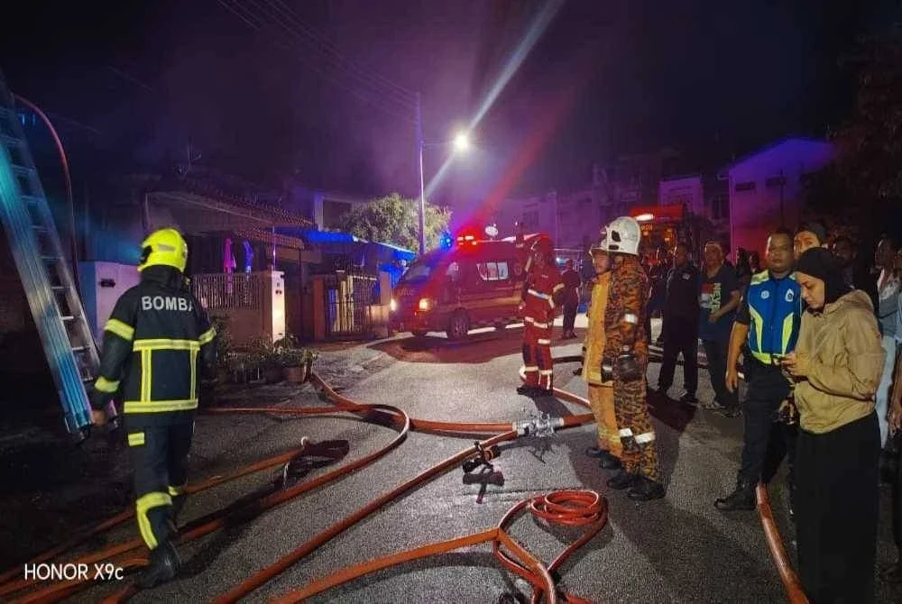 Anggota bomba berusaha memadamkan kebakaran rumah berkenaan.