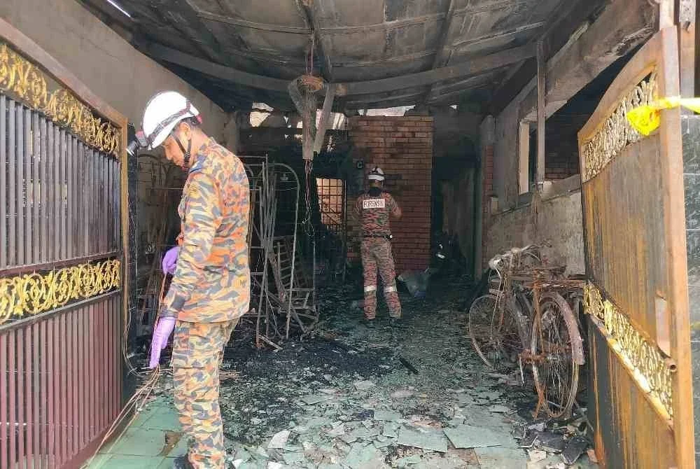 Anggota Bahagian Penyiasatan Kebakaran JBPM Perak sedang memeriksa rumah mangsa yang terbakar sehingga mengorbankan tiga nyawa di Taman Desa Tambun di sini pada Ahad.
