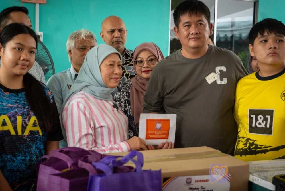 Nancy (tiga dari kanan) menyampaikan sumbangan PEKA kepada keluarga mendiang Debra Moset di Padawan, Sarawak pada Ahad.