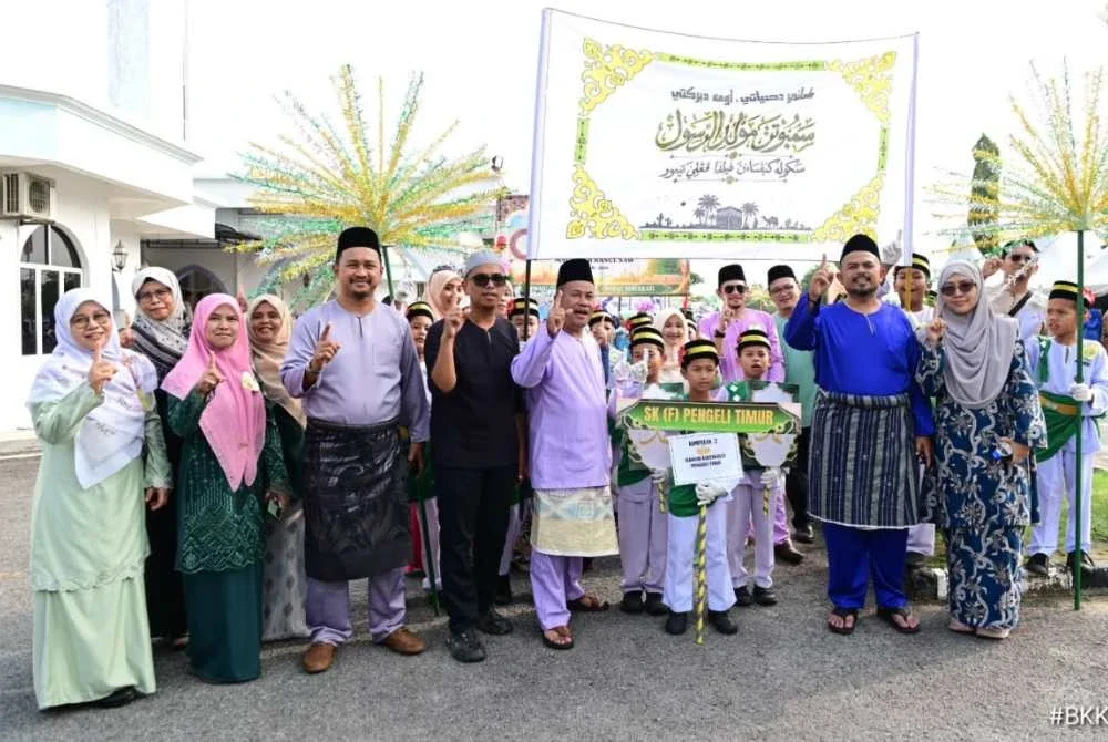 Manndzri (dua dari kanan) bersama kakitangan dan murid dari Sekolah Kebangsaan Felda Pengeli Timur yang menyertai perarakan Sambutan Maulidur Rasul di Masjid Al-Husna Bandar Tenggara, pada Ahad.